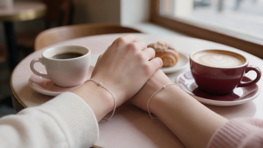 Two friends wearing matching bracelets over coffee