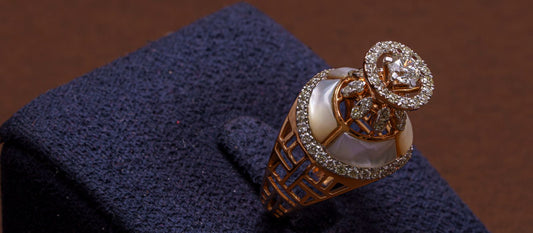 Ornate rose gold ring set with clear stones displayed on a navy velvet stand