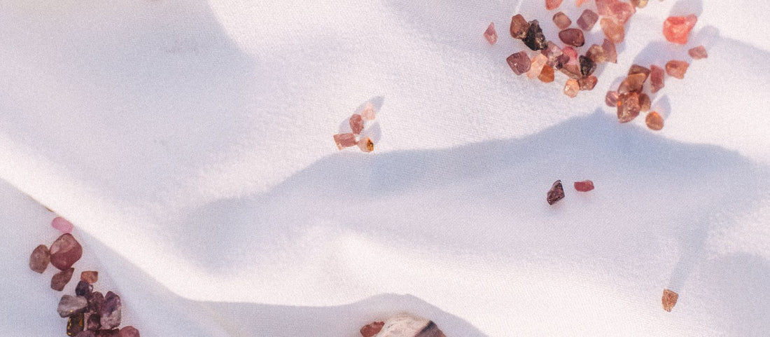 Deep red garnet crystals scattered on a pale textured surface