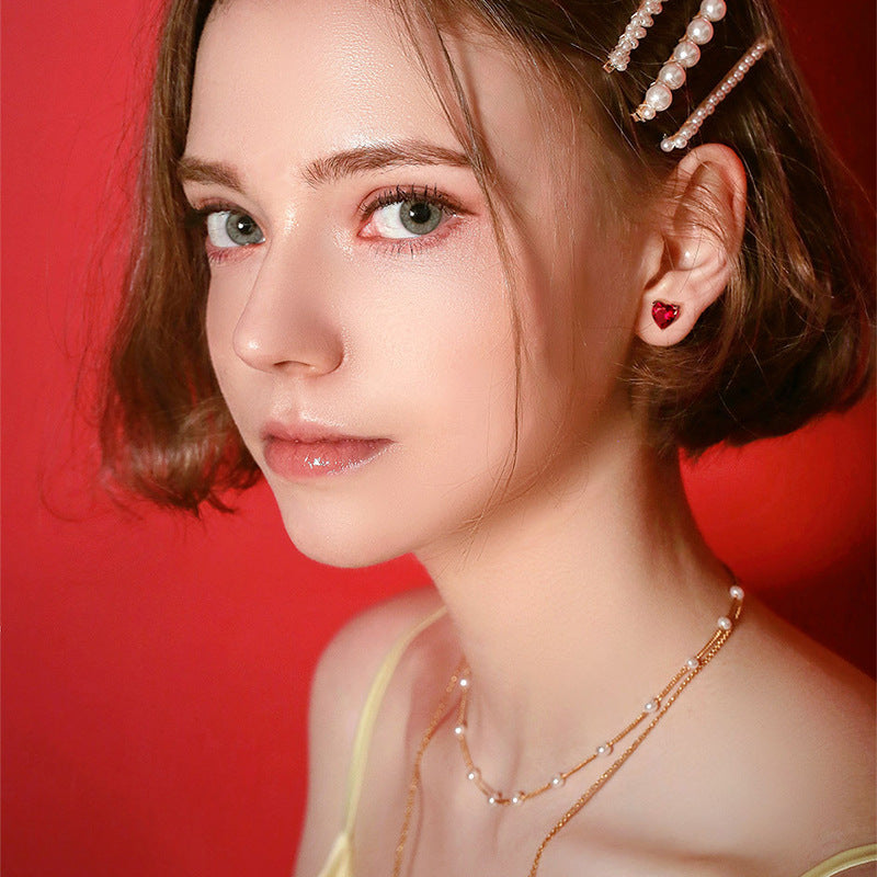 Heart stud earrings in birthstone colours, shown as a pair